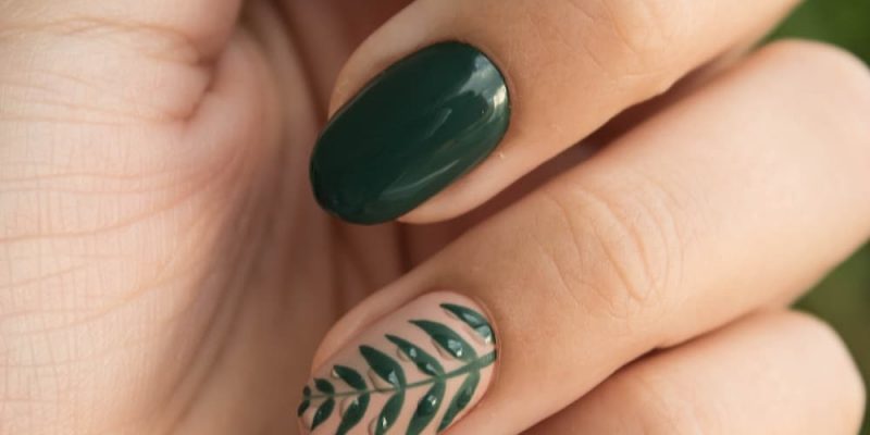 Kvindes hånd i close up med shellac negle med grøn farve og motiv